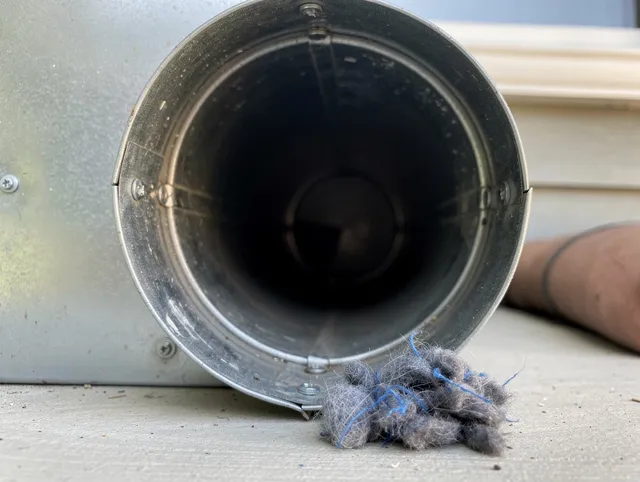 Tiverton Dryer Vent Cleaning technician using specialized equipment to clear severe dryer vent blockage in Tiverton